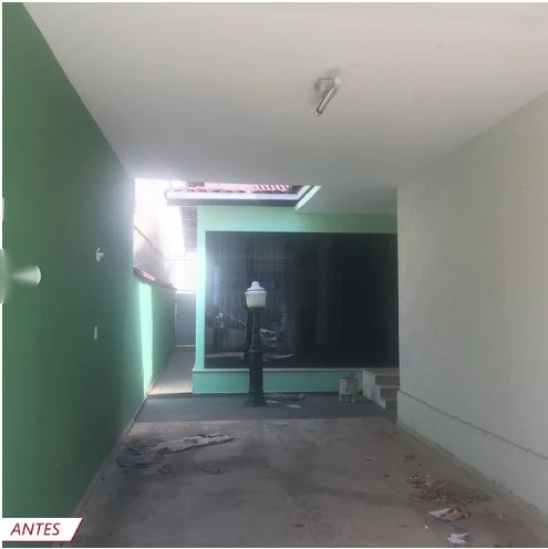 Sala vazia, com paredes verdes e piso desgastado, antes da reforma.