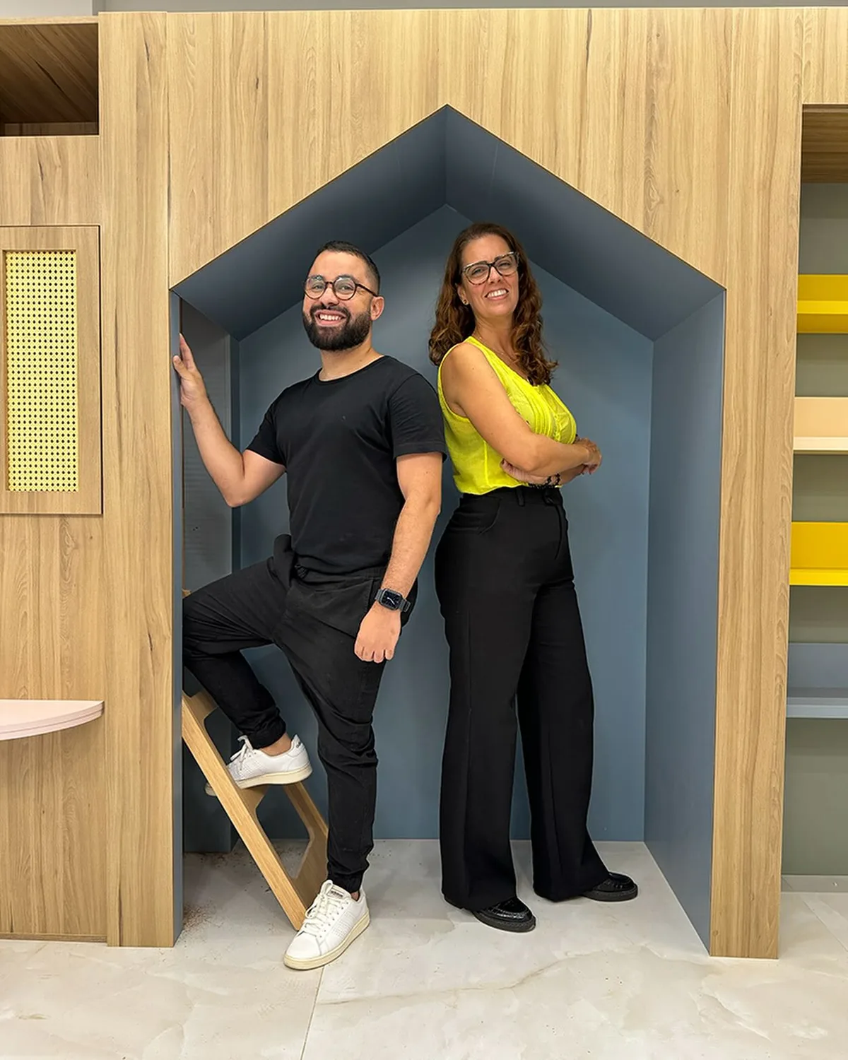 Consultório pediátrico em obra, com uma casinha de madeira e nicho azul em forma de casa.
